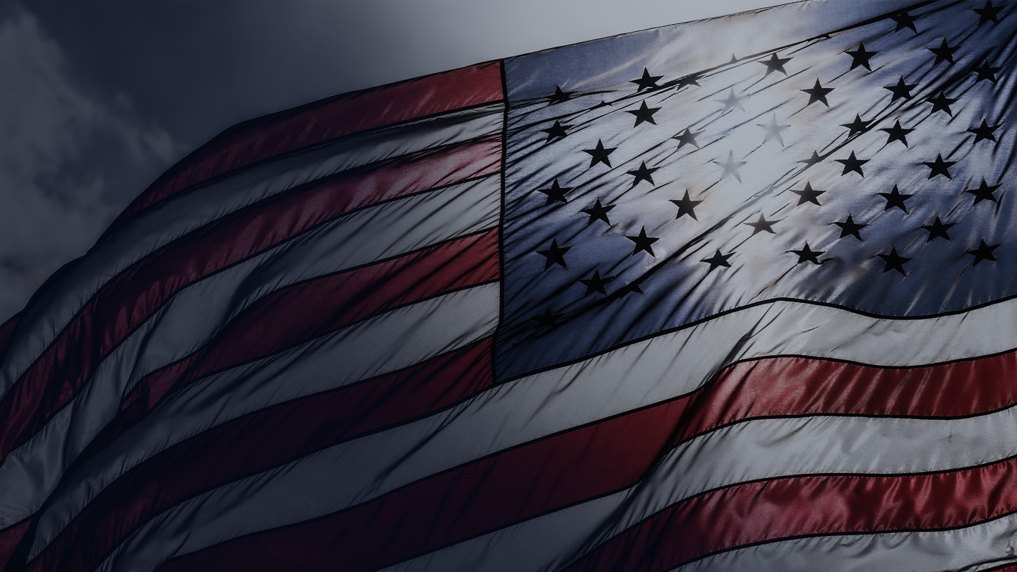 Girl running through a field holding an American flag